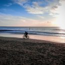 un cycliste qui pédale sur une plage