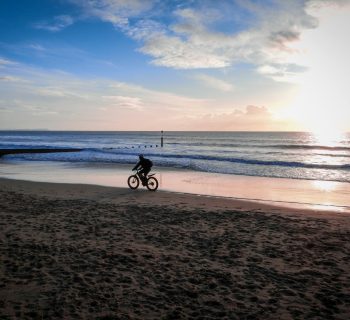 un cycliste qui pédale sur une plage